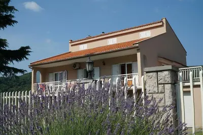 a house with purple flowers in front of it at Apartments Raskovic in Radanovići