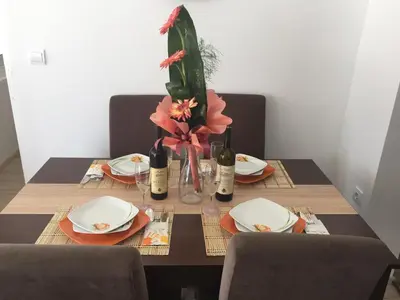 a table with plates and wine bottles and flowers on it at Apartment Ines in Bar
