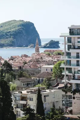 a city with buildings and a church and the water at Hotel Arka in Budva