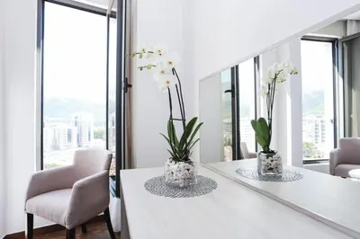 a dining room with white tables and chairs and windows at Hotel Arka in Budva