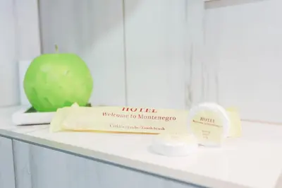 a counter with a block of cheese and an apple at Hotel Arka in Budva