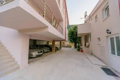a driveway of a building with cars parked in it at Paradise Bay Apartments in Kotor