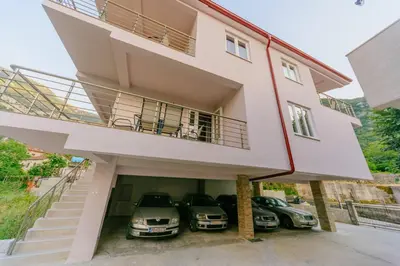 a house with three cars parked in the garage at Paradise Bay Apartments in Kotor