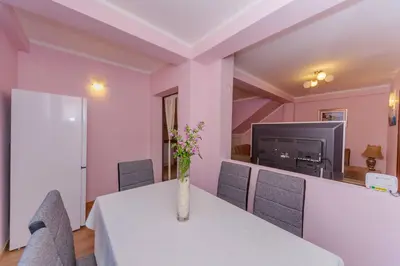 a dining room with a table with a vase of flowers on it at Paradise Bay Apartments in Kotor