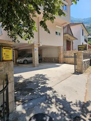 a building with a car parked in a driveway at Paradise Bay Apartments in Kotor