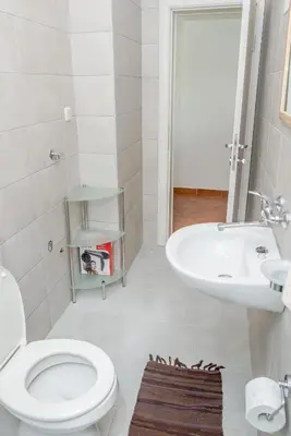 a white bathroom with a toilet and a sink at Apartments Dali in Budva
