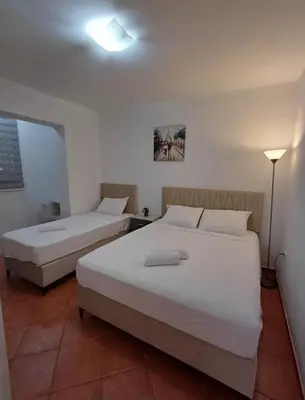 a bedroom with two beds and a lamp at Apartments Dali in Budva