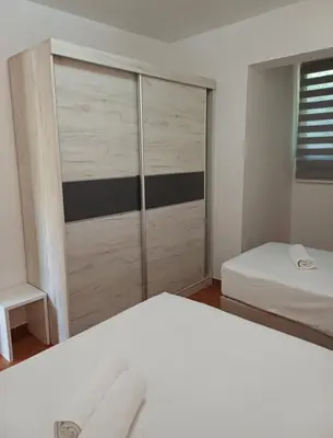 a bedroom with two beds and a sliding door at Apartments Dali in Budva