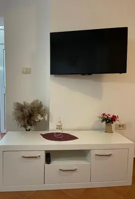 a white cabinet with a flat screen tv on the wall at Apartments Dali in Budva