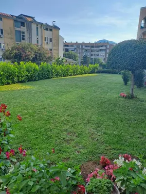 a large yard with flowers and buildings in the background at Apartments Dali in Budva