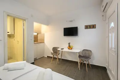 a living room with a table and chairs in a room at Apartments Dali in Budva