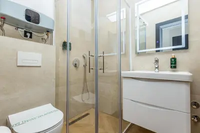 a bathroom with a shower and a toilet and a sink at Continental Hotel in Ulcinj