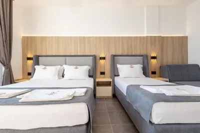 a hotel room with two beds and a chair at Continental Hotel in Ulcinj