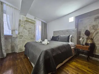 a bedroom with a bed with two stuffed animals on it at Athos Guesthouse in Kotor