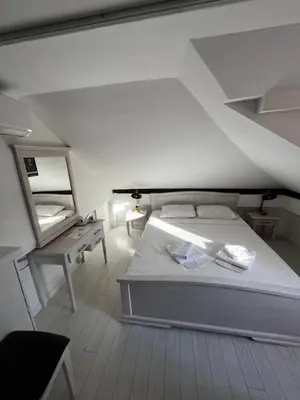a bedroom with a white bed and a mirror at Athos Guesthouse in Kotor