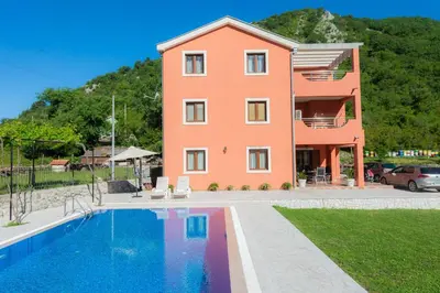 a house with a swimming pool in front of it at Milas Trojica Kotor in Kotor