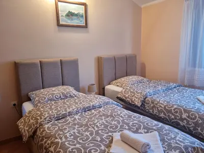 a bedroom with two beds and a picture on the wall at Milas Trojica Kotor in Kotor