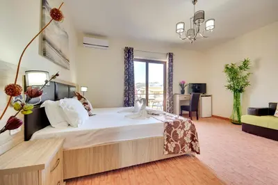 a bedroom with a large bed and a living room at Spa Hotel Montefila in Ulcinj