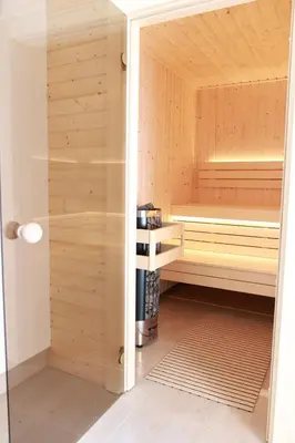 a sauna with wooden walls and a glass door at Apartments Pribilovic in Budva