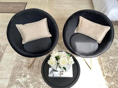 two black chairs and a table with a vase of flowers at Apartments Pribilovic in Budva