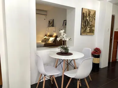a dining room with a table and chairs and a bedroom at Apartments Pribilovic in Budva