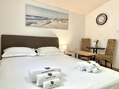a hotel room with a bed with towels on it at Apartments Pribilovic in Budva