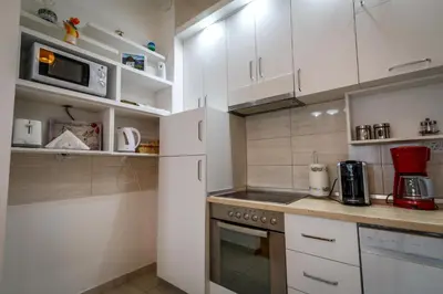 a kitchen with white cabinets and a stove top oven at Luxury Budva Center Apartments in Budva