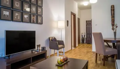 a living room with a television and a table and chairs at Luxury Budva Center Apartments in Budva