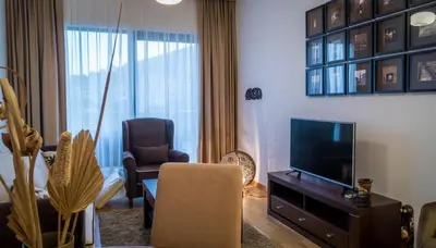 a living room with a tv and a couch and a chair at Luxury Budva Center Apartments in Budva