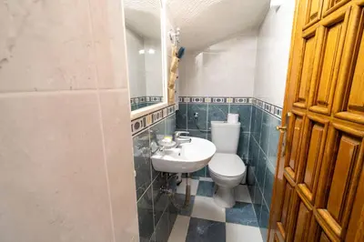 a bathroom with a white toilet and a sink at Studios Belvi in Kotor