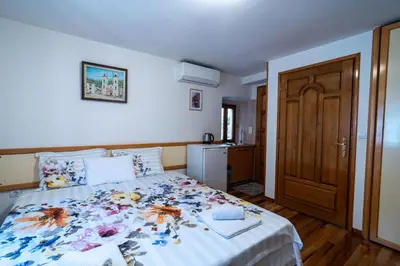 a bedroom with a bed with a floral bedspread at Studios Belvi in Kotor