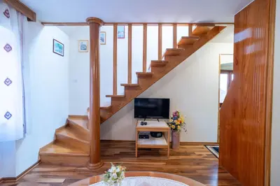 a living room with a staircase with a television at Studios Belvi in Kotor