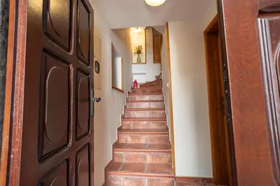 a hallway with a wooden door and a staircase at Studios Belvi in Kotor