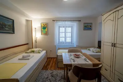 a small room with two beds and a table at Studios Belvi in Kotor