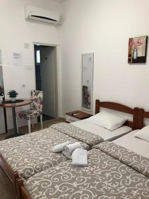 a bedroom with two beds and a table and a chair at D&D Budva in Budva