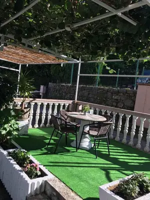 a patio with a table and chairs on green grass at D&D Budva in Budva