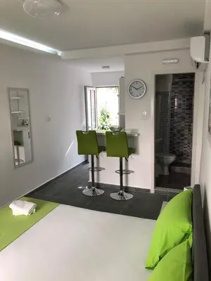 a living room with green chairs and a table at D&D Budva in Budva