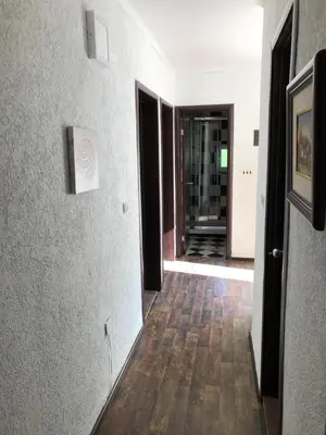 a hallway with white walls and a wooden floor at D&D Budva in Budva