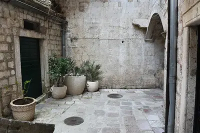 a courtyard with potted plants in a building at Apartment Miguel in Kotor