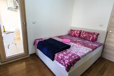 a small bedroom with a bed with a pink paper on it at De Lux Apartments in Petrovac na Moru