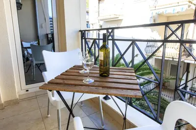 a bottle of wine and a glass on a table on a balcony at De Lux Apartments in Petrovac na Moru