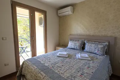 a bedroom with a bed with two towels on it at De Lux Apartments in Petrovac na Moru