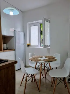 a kitchen with a table and chairs and a refrigerator at Apartmani Hortenzija in Budva