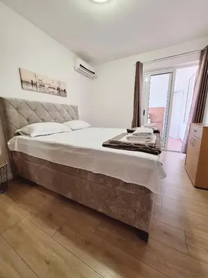 a bedroom with a large bed and a large window at Apartmani Hortenzija in Budva