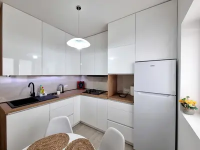 a kitchen with white cabinets and a table and chairs at Apartmani Hortenzija in Budva