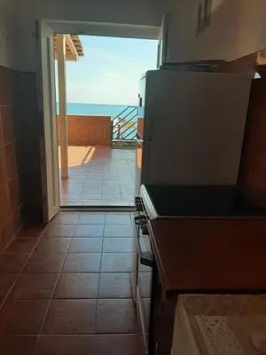 a kitchen with a stove and a view of the ocean at Beach House Buljarica in Petrovac na Moru
