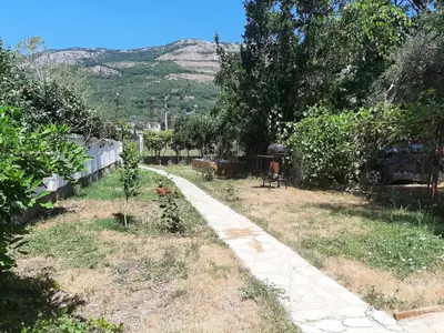 a path in a garden with a mountain in the background at Beach House Buljarica in Petrovac na Moru