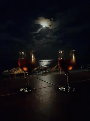 three wine glasses sitting on a table with the moon at Beach House Buljarica in Petrovac na Moru