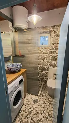 a bathroom with a toilet and a washing machine at Beach House Buljarica in Petrovac na Moru