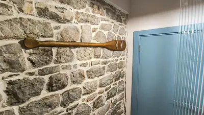 a wooden baseball bat hanging on a stone wall at Beach House Buljarica in Petrovac na Moru